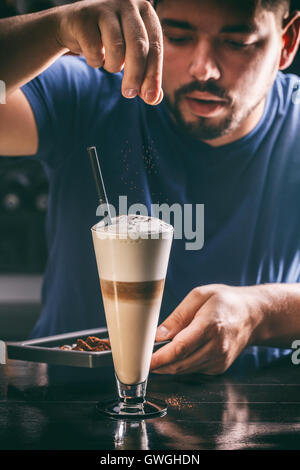 Barista decorazione di latte o caffè cappuccino Foto Stock