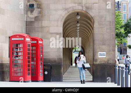 Telefono rosso caselle e una stazione di polling segno a Manchester Town Hall , REGNO UNITO Foto Stock