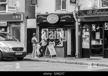 Le donne con i tatuaggi al di fuori del salotto tattoo. Kettering rd, Northampton. Foto Stock