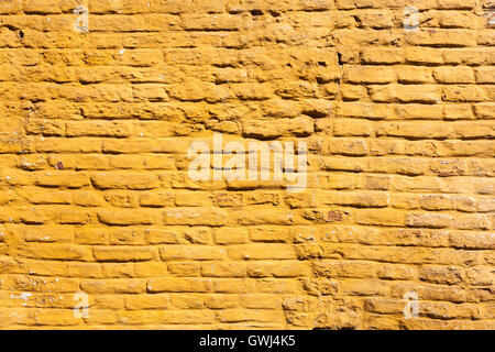 Parte quadrata di colore giallo ocra dipinte di un muro di mattoni Foto Stock