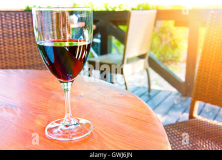 Bicchiere di vino rosso sul tavolo nel ristorante dell'estate. Foto Stock