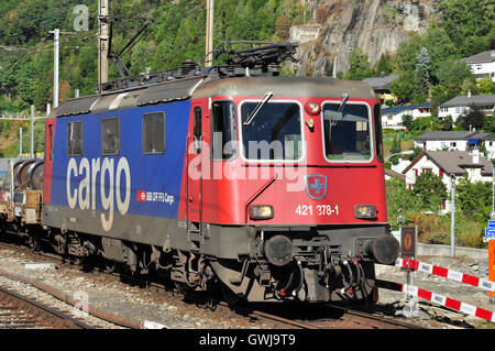 Re 4/4 n. 421 378-1 approcci con un treno merci a Briga stazione ferroviaria, Vallese, Svizzera Foto Stock