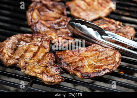 Carne di maiale alla griglia quasi pronto sulla griglia Foto Stock