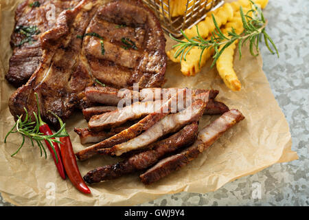 Carne di maiale alla griglia con patate fritte Foto Stock