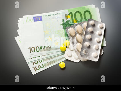 Un centinaio di banconote in euro e pillole closeup Foto Stock