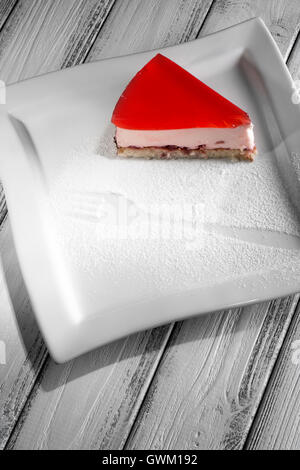 Pezzo di torta di gelatina bianca su sfondo di legno. Foto Stock