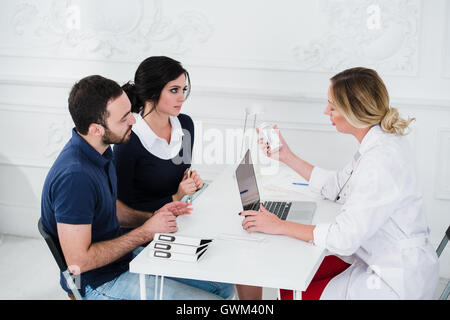 Felice Coppia Giovane dando una busta medico donna Foto Stock