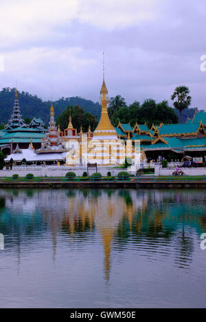I templi Wat Jong Kham e Wat Jong Klang, che mostrano i caratteristici stili architettonici Tai Yai (Shan) e birmano riflessi nelle calme acque del lago Nong Chong Kham a Mae Hong Son, una remota e montuosa provincia nel nord della Thailandia, al confine con il Myanmar (Birmania) Foto Stock