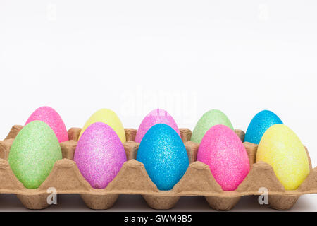 Glitter coperto fake uova di pasqua in una confezione di uova Foto Stock