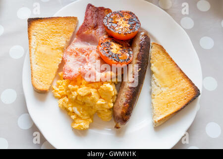 Café pasto una piccola prima colazione inglese con bacon uova strapazzate, salsiccia e pomodoro fritto servito nello Yorkshire Foto Stock