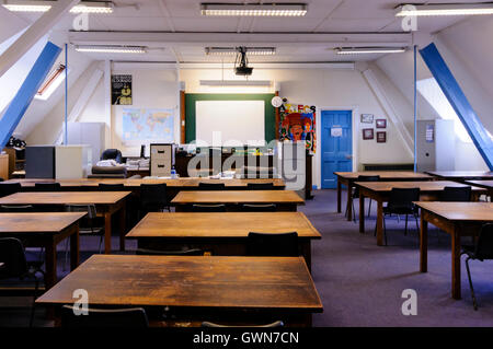 Vecchi banchi di legno in un aula tradizionale Foto Stock