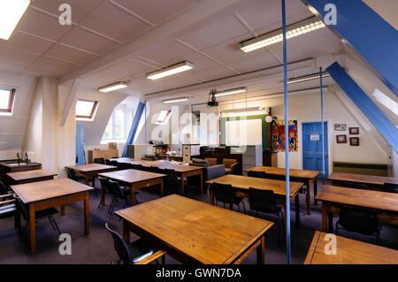 Vecchi banchi di legno in un aula tradizionale Foto Stock