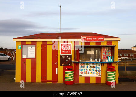 Rosso e giallo listati della parete del gelato chiosco in un pomeriggio invernale, Seaford, East Sussex, Inghilterra Foto Stock