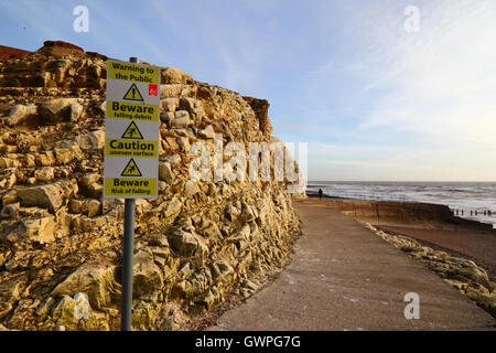 Cartelli di avvertimento accanto a Chalk scogliere sulla promenade, Seaford, East Sussex, Inghilterra Foto Stock