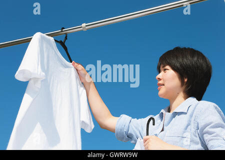 Giovane donna giapponese facendo servizio lavanderia Foto Stock