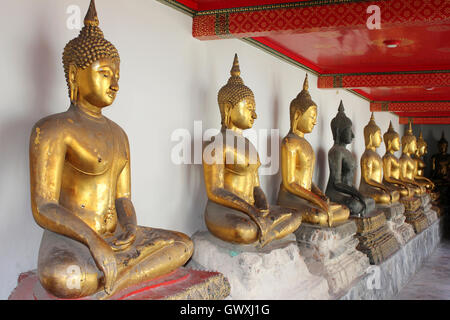 Linea di Buddha seduto al Wat Pho tempio di Bangkok, Tailandia Foto Stock