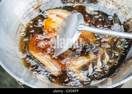 Frittura di pesce in olio sul fuoco Foto Stock