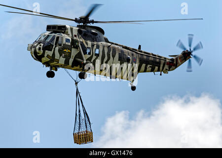 La Royal Navy Westland Sea King HC.4, ZE424/WR elicottero trasporta un carico underslung presso gli RNAS Yeovilton International Air giorno. Foto Stock