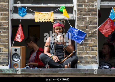 Persone in windows durante il carnevale di Notting Hill celebrazioni Foto Stock