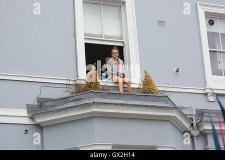 Persone in windows durante il carnevale di Notting Hill celebrazioni Foto Stock