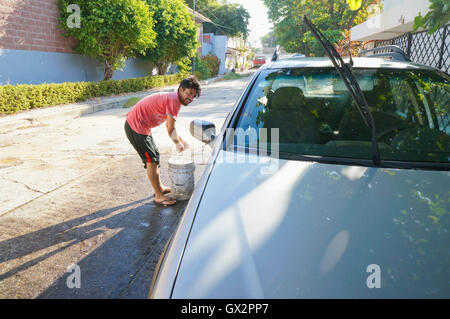 Uomo messicano il lavaggio auto in Acapulco, Messico Foto Stock