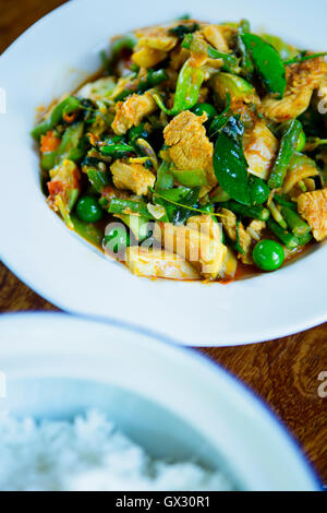 Thai stir fry con pollo, fagioli, piselli, basilico fresco e foglie di combava Foto Stock