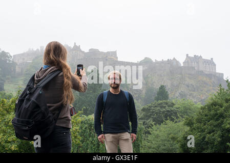 Edimburgo, Scozia, Regno Unito. 15 Settembre, 2016. Meteo standalone. Come registrare le temperature per il mese di settembre sono state registrate in alcune parti del Regno Unito altre aree non sono stati così fortunati. Alison Raone, 22 e Jimmy Collin, 26 dal Belgio di terminare le turbine viaggio intorno alla Scozia nella parte anteriore di una nebbia avvolta dal Castello di Edimburgo. Edinburgh 16 - Londra 27. Foto Stock