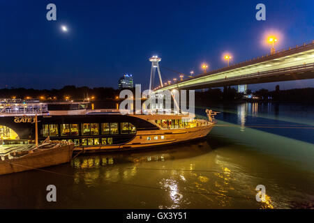 Barche sotto il Ponte della rivolta nazionale slovacca (SNP) con ristorante UFO, Danubio, Bratislava, Slovacchia, Europa nave Danubio illumina il fiume europeo Foto Stock