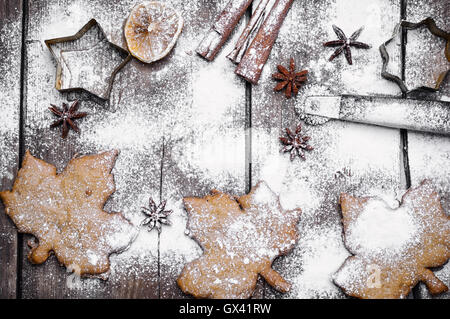 I cookie di piccante in forma di foglie di acero coperti di neve sullo sfondo di legno Foto Stock