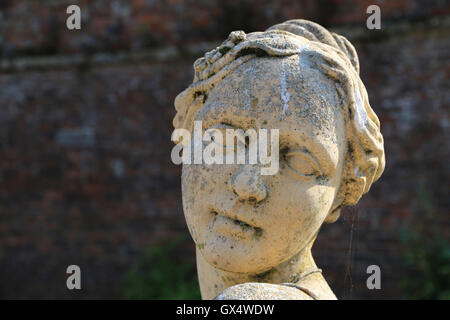 Statua di Pietra della testa femmina, un giardino ornamentale Foto Stock