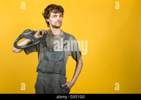 Bello sorridente meccanico con un giallo ruota Foto Stock