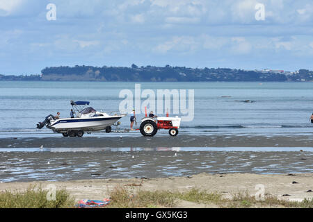 Il traino del trattore motoscafo sulla spiaggia sabbiosa Foto Stock