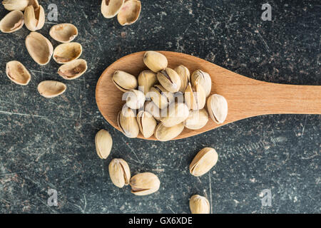 Il pistacchio dadi sul cucchiaio di legno. Vista dall'alto. Foto Stock