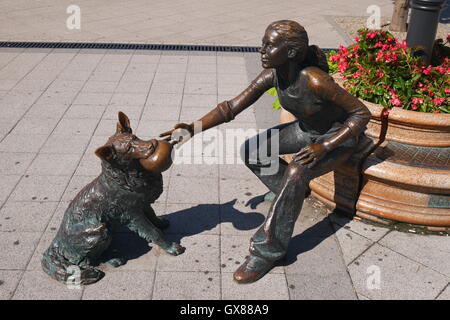 Statua in bronzo Raffay David di una ragazza che gioca con un cane, piazza Vigado, Danubio embankment, Budapest, Ungheria Foto Stock