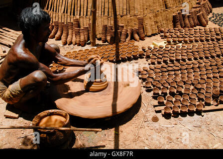 INDIA, nello stato del Jharkhand, Sarwan, villaggio Bhatkundi, piccola scala business, ceramiche, potter rende unidirezionale di tazze di tè da argilla sull'uomo-powered giradischi, le tazze vengono venduti a chai gabbie di plastica prodotti gratuiti Foto Stock