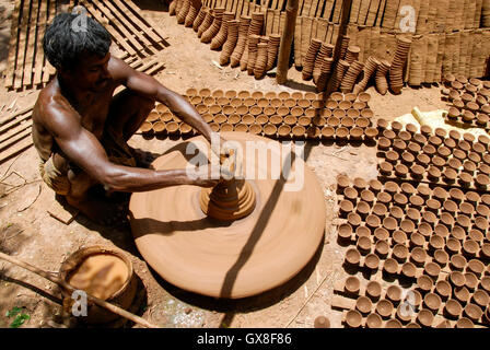 INDIA, nello stato del Jharkhand, Sarwan, villaggio Bhatkundi, piccola scala business, ceramiche, potter rende unidirezionale di tazze di tè da argilla sull'uomo-powered giradischi, le tazze vengono venduti a chai gabbie di plastica prodotti gratuiti Foto Stock