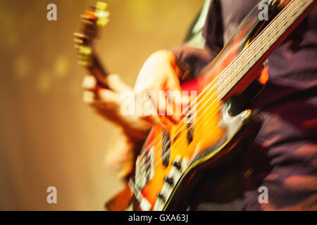 Colorata sfumata la musica rock di sfondo, i chitarristi su un palco, motion blur effetto retrò e la correzione delle tonalità filtro, vecchio di Foto Stock
