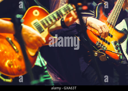 Colorata rock e musica di sottofondo, giocatori di chitarra su un palco, messa a fuoco selettiva e retrò la correzione delle tonalità effetto di filtro Foto Stock