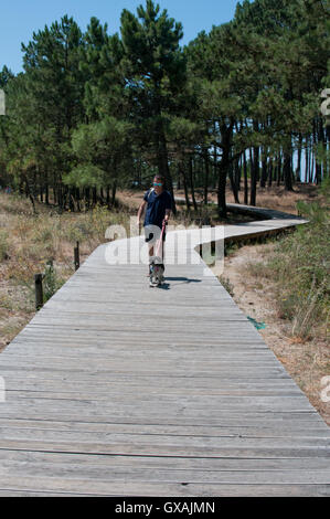 Uomo e cane sul Boardwalk Foto Stock