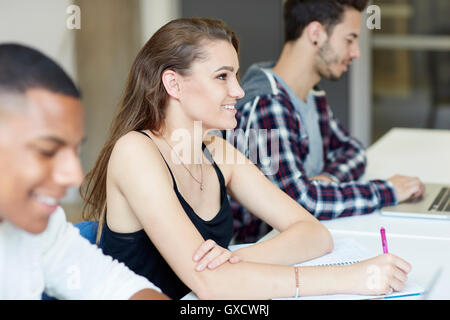 Gli studenti a prendere appunti in materia di istruzione superiore college classroom Foto Stock