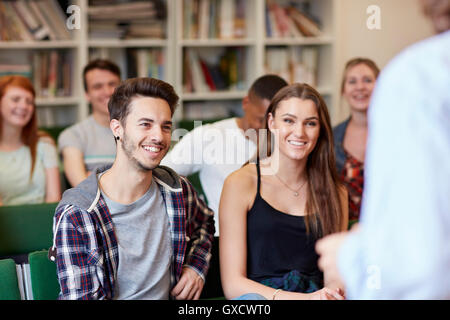 Sulla spalla vista del docente lezioni gruppo di studenti nell'istruzione superiore college classroom Foto Stock