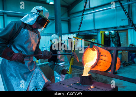 Maschio lavoratori fonderia bronzo versatore melting pot in fonderia di bronzo Foto Stock