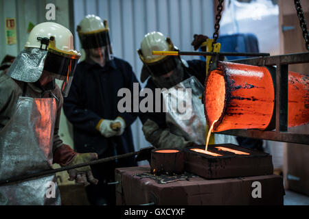 Maschio lavoratori fonderia bronzo versatore melting pot in fonderia di bronzo Foto Stock