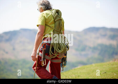 Vista posteriore del rocciatore che trasportano arrampicata fune sul retro Foto Stock