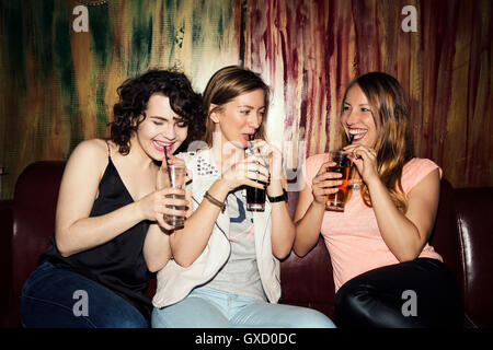 Tre femmina adulta gli amici a bere in bar Foto Stock