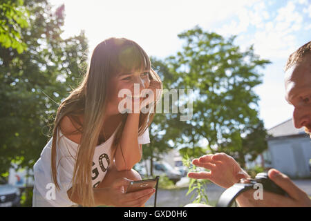 Coppia giovane all'aperto, ascoltare la musica tramite auricolari Foto Stock