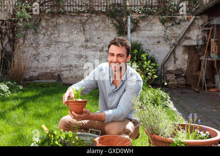 L uomo nel giardino di cura delle piante Foto Stock