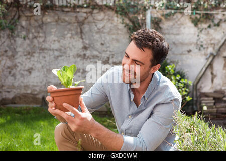 L uomo nel giardino di cura delle piante Foto Stock