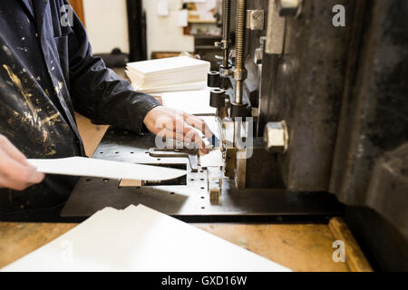 Stampante maschio la preparazione di carta per macchine di stampa in macchina da stampa workshop Foto Stock