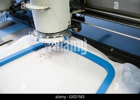 Close up programmato di macchina da ricamo velocità panno di cucitura in fabbrica di abbigliamento Foto Stock